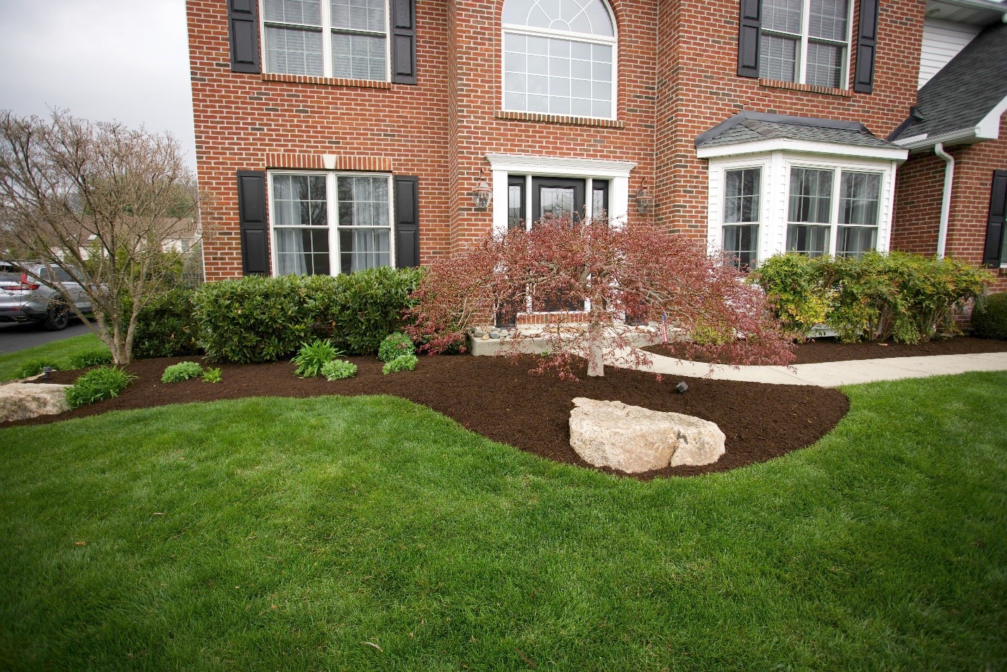 A lush, green lawn by a brick home.